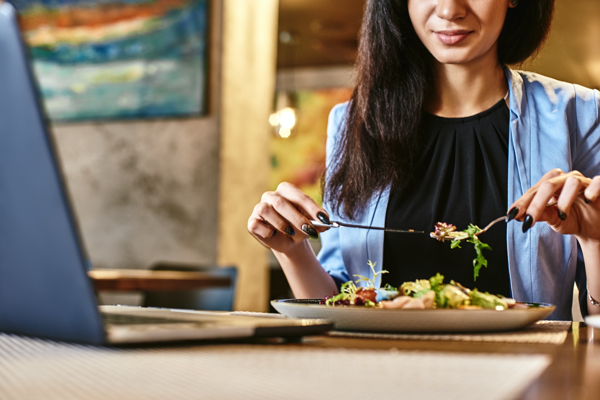 Snack time heals all wounds. Businesswoman having lunch in company's restaurant. Cozy interior